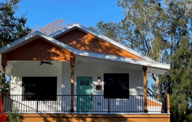 A single-story house with a white exterior, a teal front door, and a covered porch — 1482 CLEVELAND STREET, CLEARWATER, FL