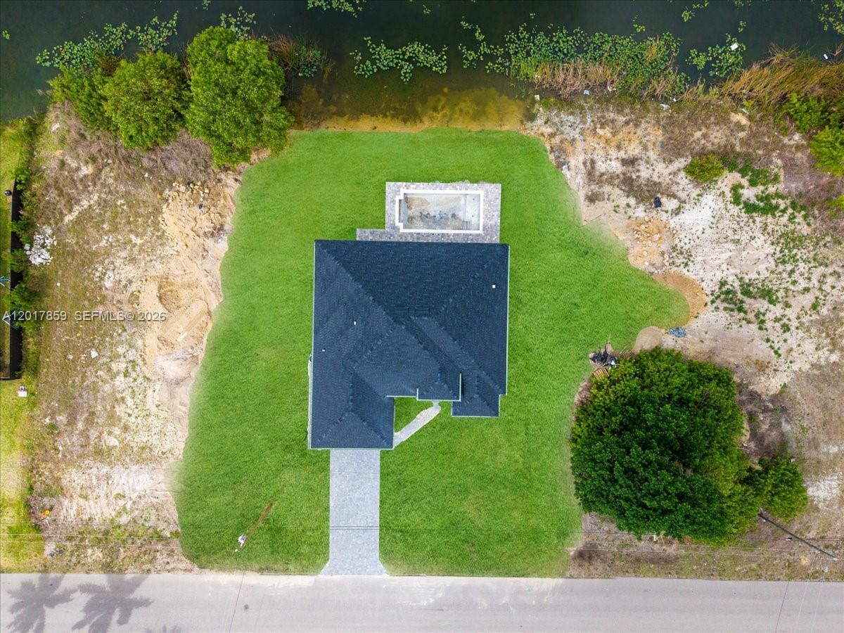 An aerial view shows a house with a pool on a lot near water — 502 NE 5th PL, Cape Coral FL 33909, CAPE CORAL, FL