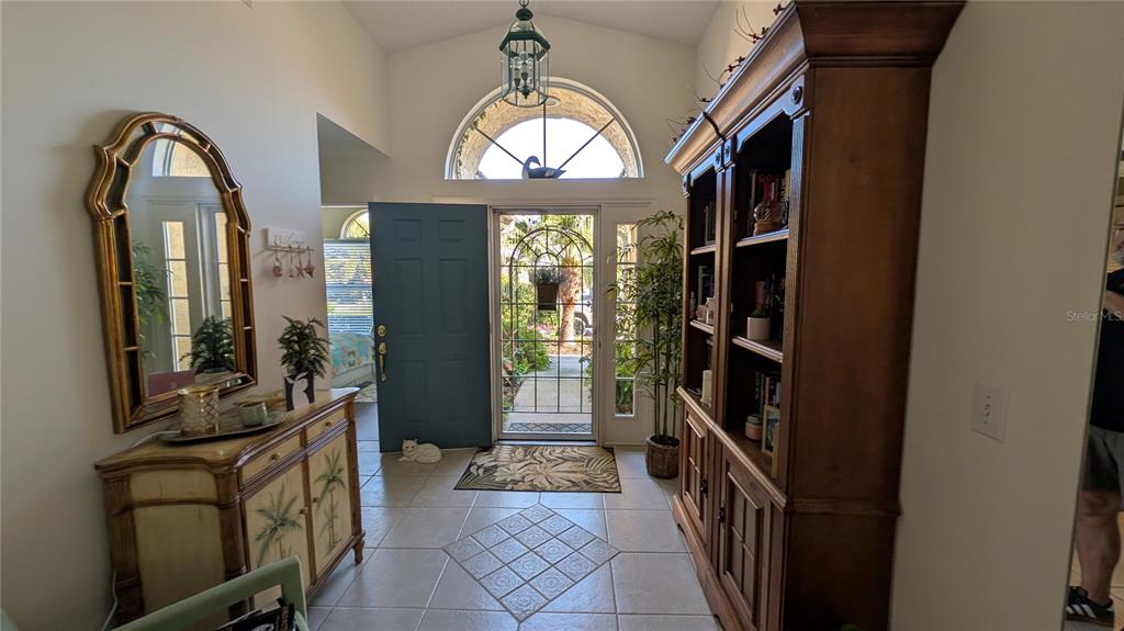 An entryway features tile flooring, a wooden hutch, a decorative mirror, and a glass-paneled door — 5406 83RD TERRACE E, SARASOTA, FL