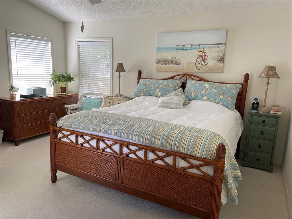 A kitchen with white cabinets, tile flooring, a stainless steel refrigerator, and a wooden island — 5406 83RD TERRACE E, SARASOTA, FL