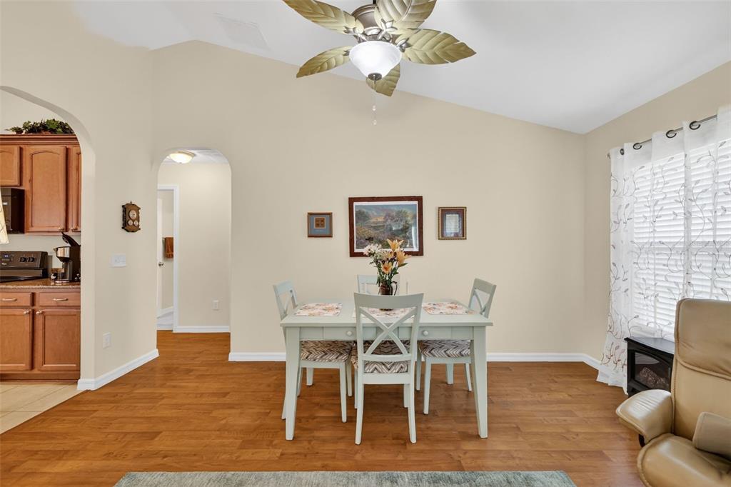 A dining area features a light-colored table, four chairs, a ceiling fan, and hardwood floors — 11217 SE 170TH LANE, SUMMERFIELD, FL