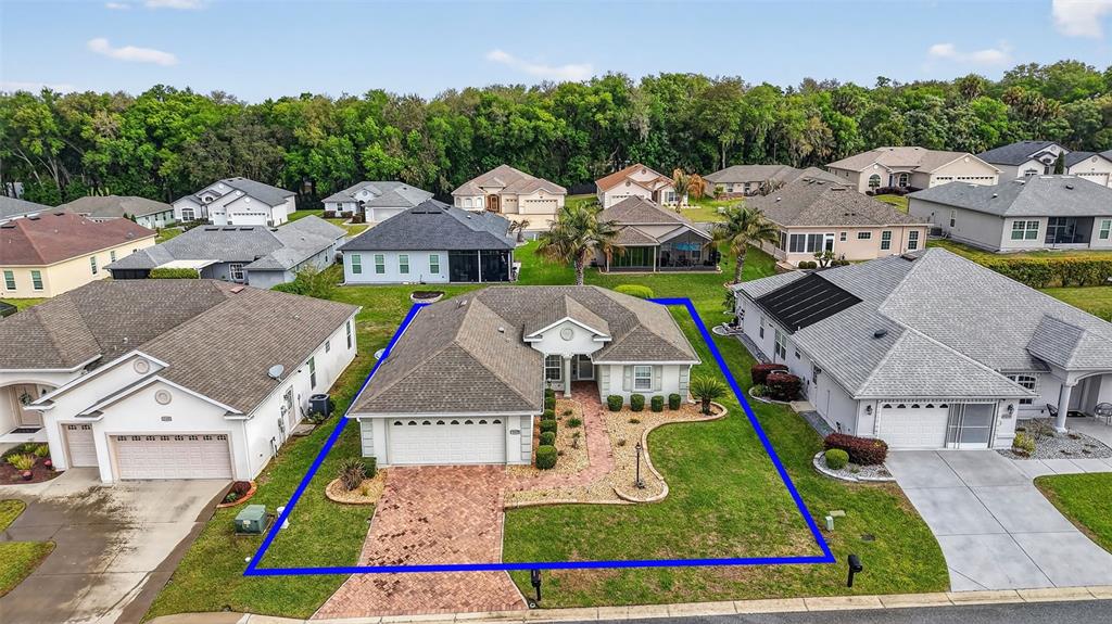 An aerial view shows a single-story house with a brick driveway and a landscaped yard — 11217 SE 170TH LANE, SUMMERFIELD, FL