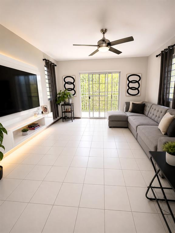 A living room features a grey sectional sofa, a wall-mounted television, and tile flooring — 843 CAM LOS RAMOS, TRUJILLO ALTO, PR