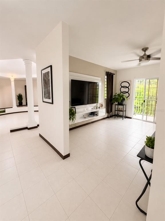 A living room features a wall-mounted television, white tile flooring, and a sliding glass door — 843 CAM LOS RAMOS, TRUJILLO ALTO, PR
