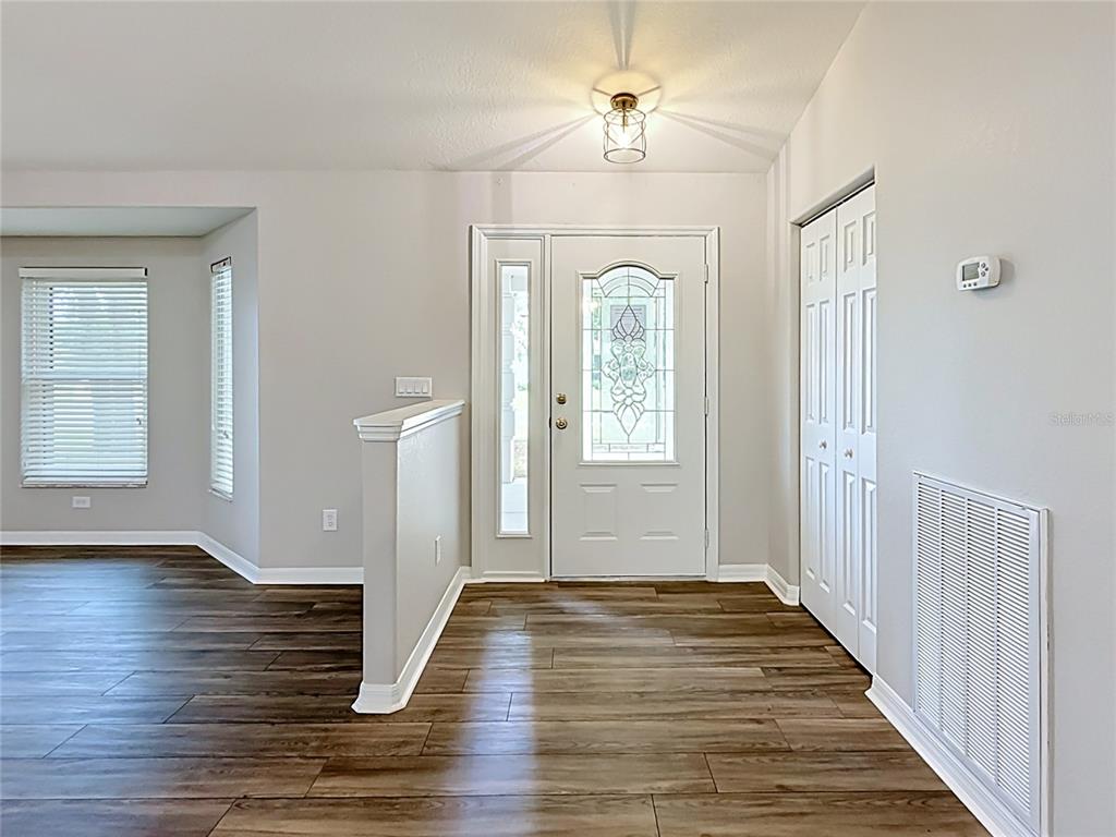 An entryway features wood-look flooring, a white front door with glass, and a small closet — 9537 SW 53RD CIRCLE, OCALA, FL
