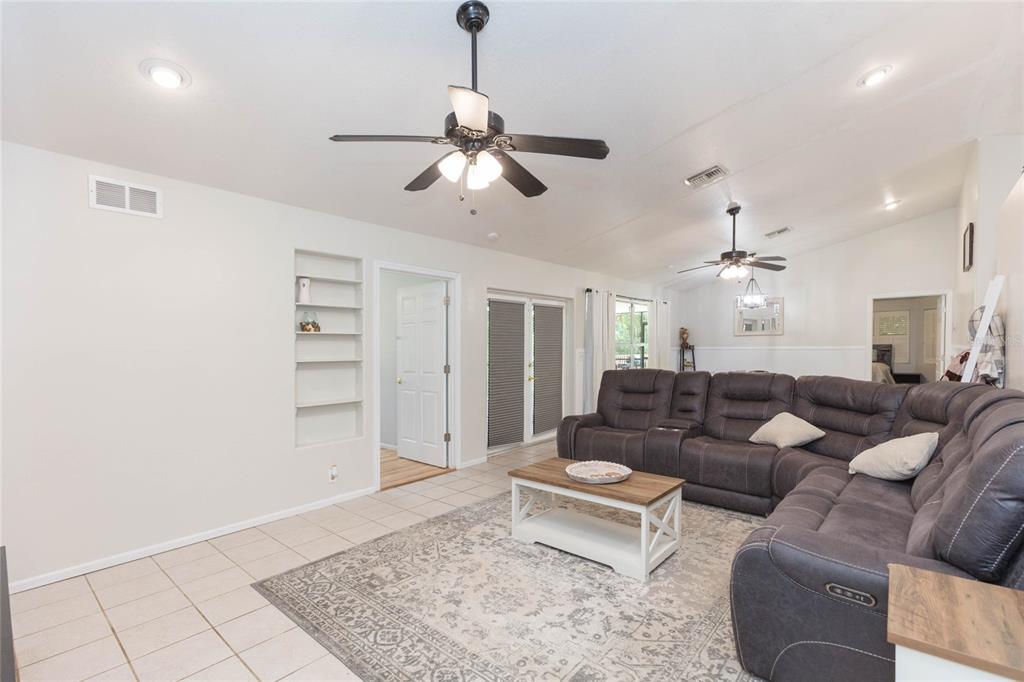 A living room features a large gray sectional sofa, a coffee table, and ceiling fans — 34299 BELT DRIVE, DADE CITY, FL