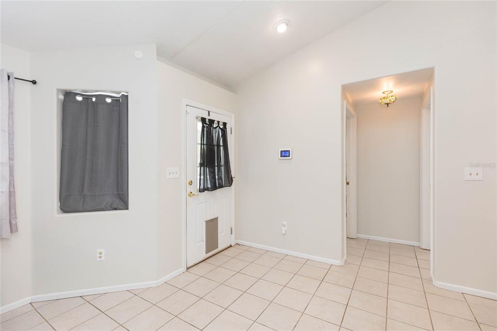 An entryway features light-colored tile flooring, a white front door, and a hallway entrance — 34299 BELT DRIVE, DADE CITY, FL
