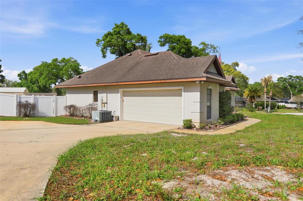 A tan house with a brown roof and a two-car garage sits on a lot — 731 EDGEWILD COURT, ORANGE CITY, FL