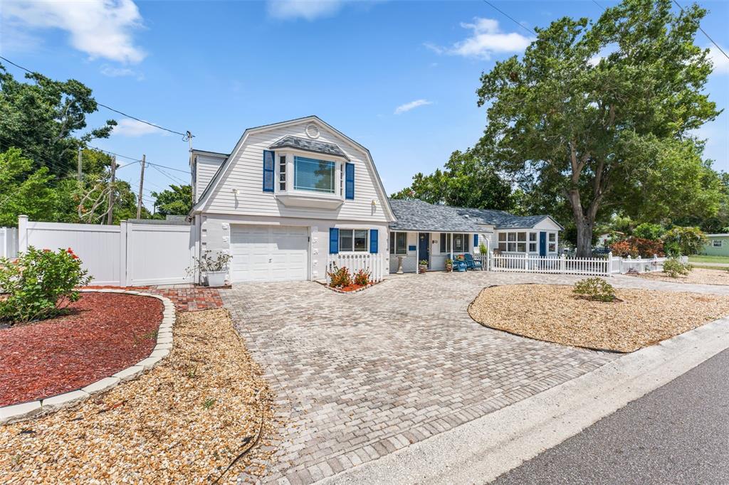 A two-story house with white siding, blue shutters, and a large paved driveway — 601 45TH STREET N, ST PETERSBURG, FL