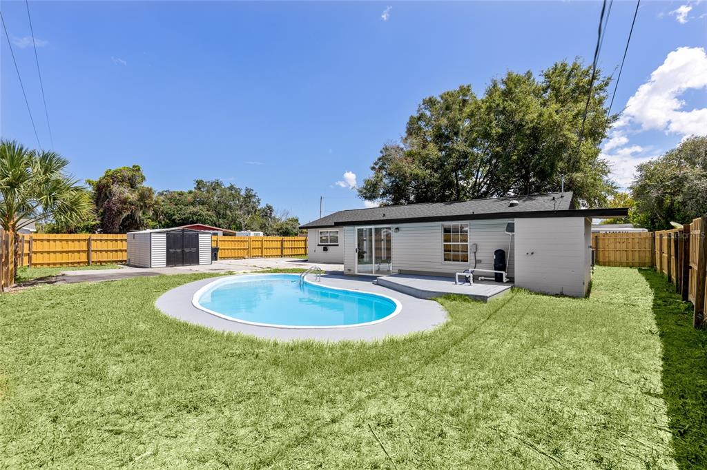 A backyard features a swimming pool, a small deck, and a detached shed — 1259 SCOTTSDALE DRIVE, ORMOND BEACH, FL