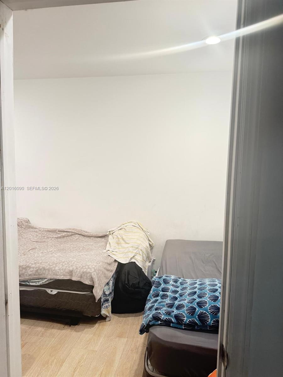 A bedroom features light wood-look flooring, white walls, and two beds — 920 Euclid Ave # 3, Miami Beach FL 33139, MIAMI BEACH, FL