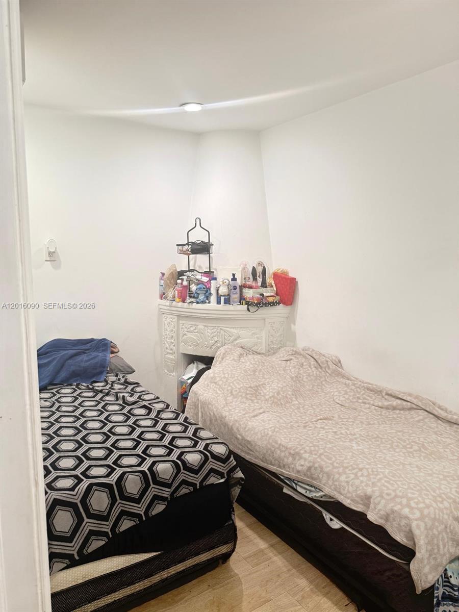A small bedroom features two twin beds and a decorative white fireplace mantel — 920 Euclid Ave # 3, Miami Beach FL 33139, MIAMI BEACH, FL