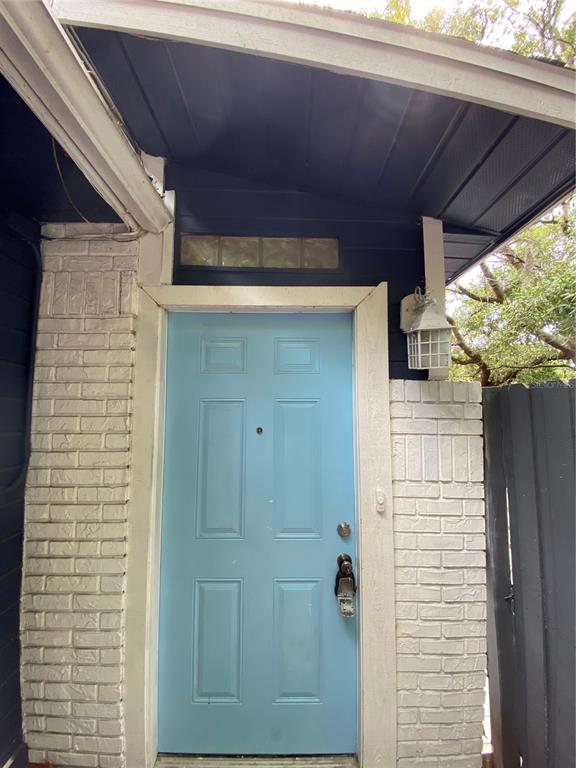 A light blue front door is framed by white painted brick and a dark overhang — 7222 NIMA COURT, ORLANDO, FL