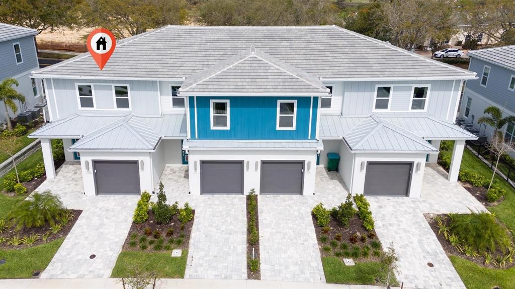 An aerial view of a multi-unit townhouse building with gray roofs and a blue facade — 7845 SPECTRUM DRIVE, KISSIMMEE, FL