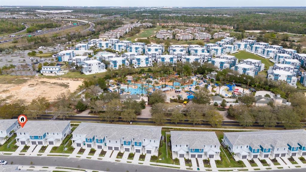 An aerial view shows a residential complex with townhomes, a swimming pool, and parking — 7845 SPECTRUM DRIVE, KISSIMMEE, FL
