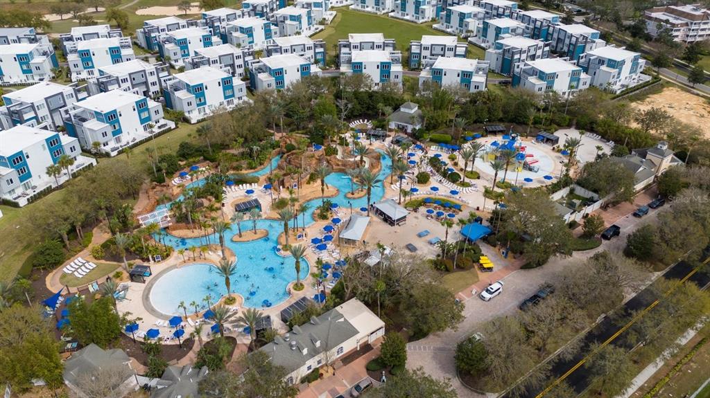 An aerial view shows a resort-style swimming pool complex surrounded by multi-story residential buildings — 7845 SPECTRUM DRIVE, KISSIMMEE, FL