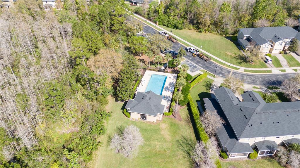An aerial view shows a community swimming pool, a clubhouse, and surrounding residential buildings — 5412 CARAMELLA DRIVE, ORLANDO, FL