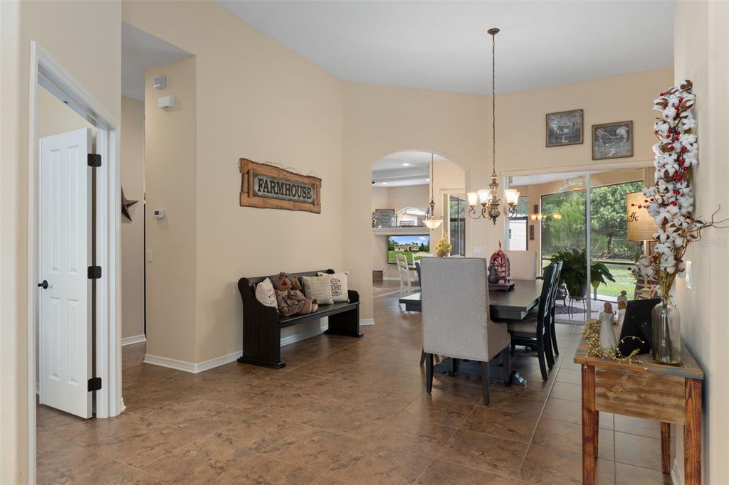 A dining area with tile floors, a wooden bench, and a chandelier opens to a living room — 4081 W ROUNDUP COURT, BEVERLY HILLS, FL