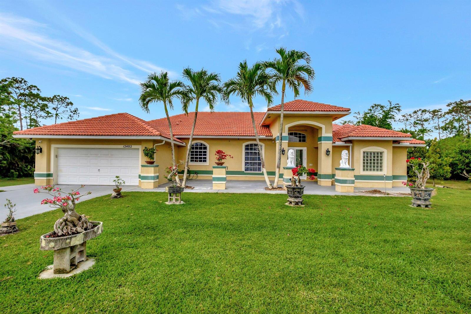 A single-story house with a red tile roof, palm trees, and a green lawn — 12402 83rd Lane N, FL 33412, FL