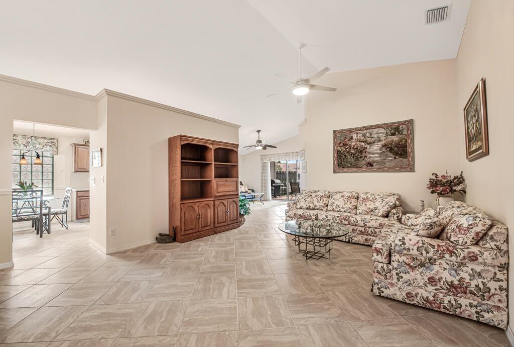 A living room with tile floors, a floral sofa, and a wooden bookshelf — 8294 Duomo Circle, Boynton Beach FL 33472, BOYNTON BEACH, FL