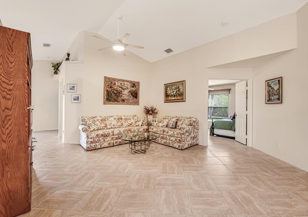 A living room with tile floors, a vaulted ceiling, and floral-patterned sofas — 8294 Duomo Circle, Boynton Beach FL 33472, BOYNTON BEACH, FL