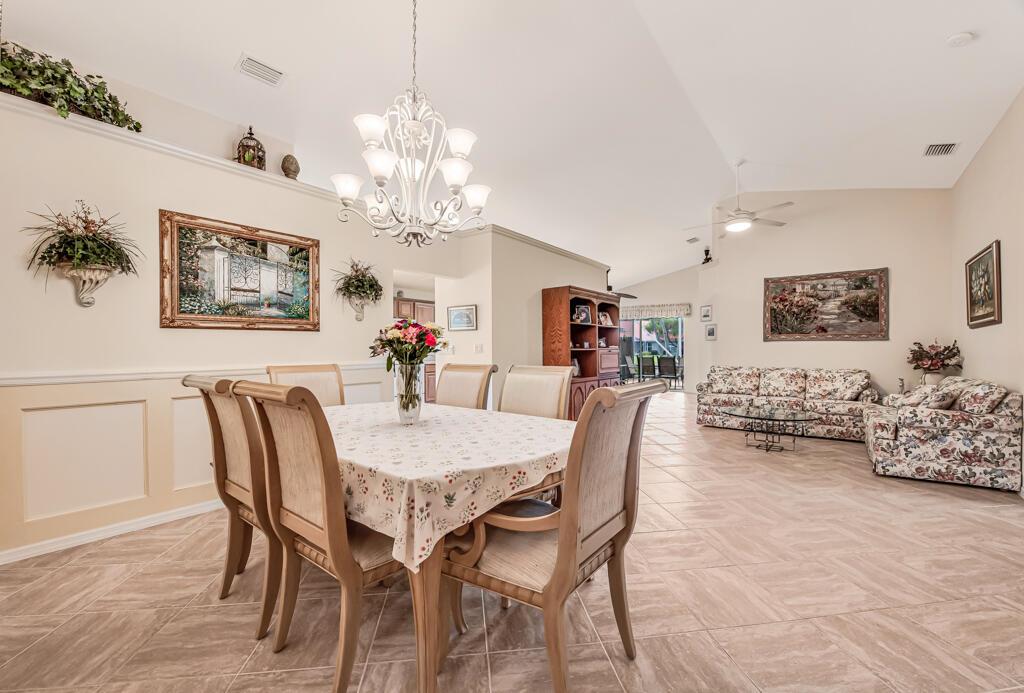 A dining area with a chandelier and table set opens into a living room — 8294 Duomo Circle, Boynton Beach FL 33472, BOYNTON BEACH, FL