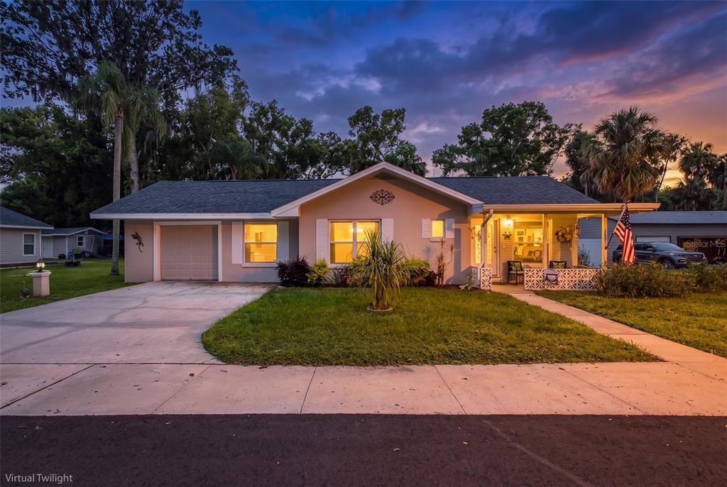 A single-story house with a garage, front porch, and lawn at twilight — 5708 HOMECREST ROAD, NEW PORT RICHEY, FL