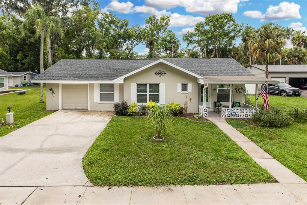 A single-story house with a concrete driveway, a small front porch, and a grassy yard — 5708 HOMECREST ROAD, NEW PORT RICHEY, FL