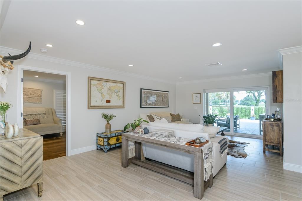 A living room features light tile floors, a sofa with a console table, and sliding doors — 2860 QUAIL HOLLOW ROAD W, CLEARWATER, FL