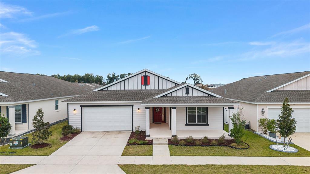 A white single-story house with a two-car garage and a covered front porch — 7513 SW 64TH STREET ROAD, OCALA, FL