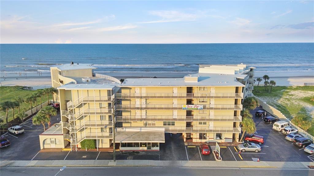 An aerial view shows a multi-story beachfront hotel complex with a parking lot and sandy beach — 1233 S ATLANTIC AVENUE UNIT 2270, DAYTONA BEACH, FL