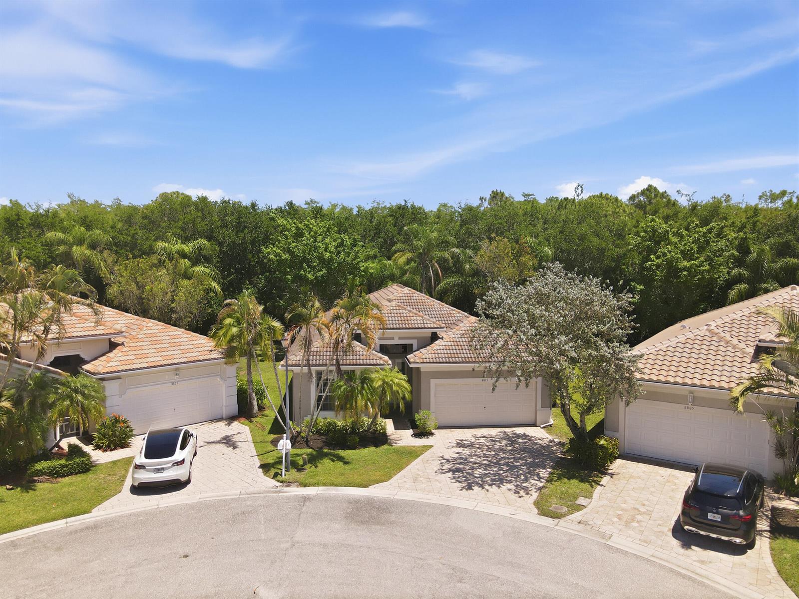 A single-story house with a beige exterior, tiled roof, palm tree, and paved driveway — 8815 Gibson Cay, West Palm Beach FL 33411, WEST PALM BEACH, FL
