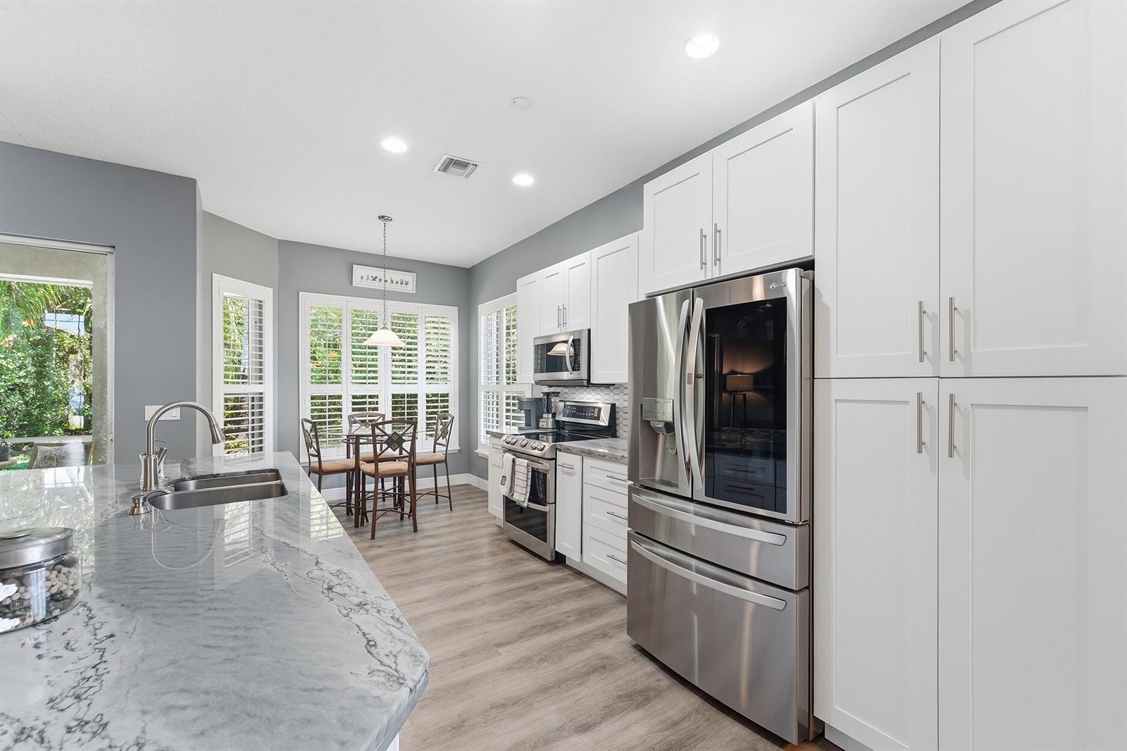 A single-story house with a beige stucco exterior, tile roof, and a paved driveway — 8815 Gibson Cay, West Palm Beach FL 33411, WEST PALM BEACH, FL