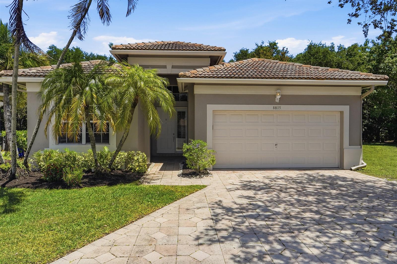 A gray-walled entryway features a wooden console table, a bird painting, and wood-look flooring — 8815 Gibson Cay, West Palm Beach FL 33411, WEST PALM BEACH, FL