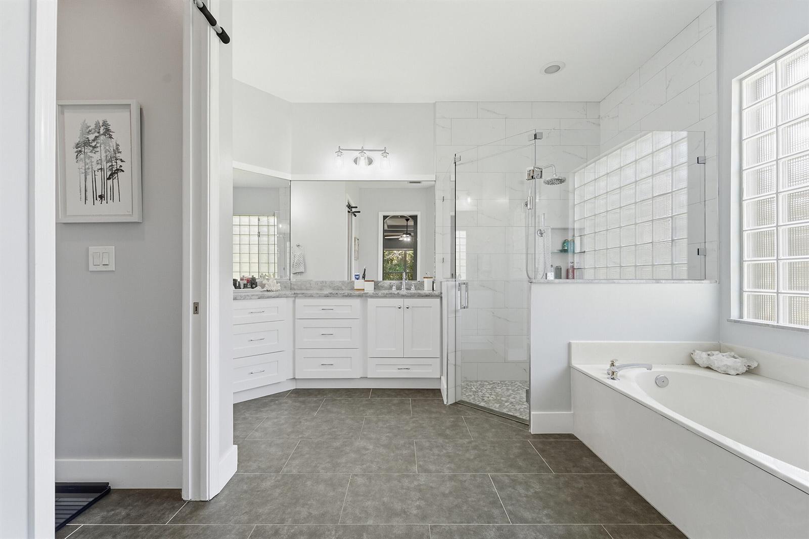 An open-concept kitchen and dining area features white cabinetry, a central island, and wood flooring — 8815 Gibson Cay, West Palm Beach FL 33411, WEST PALM BEACH, FL