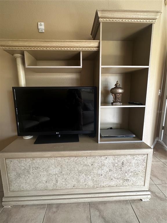 A living and dining area with tile floors, a glass table, and a sectional sofa — 8601 WORLDQUEST BOULEVARD UNIT 3-303, ORLANDO, FL
