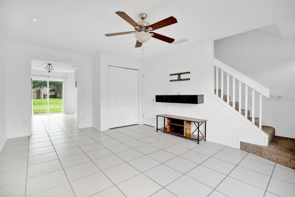 A living room with white walls, tile flooring, a ceiling fan, and a staircase — 611 CASA PARK A COURT, WINTER SPRINGS, FL