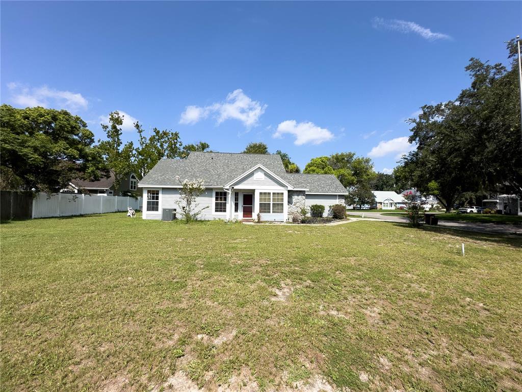 A single-story house with light siding and a stone accent wall sits on a lawn — 9901 ALOMA BEND LANE, OVIEDO, FL