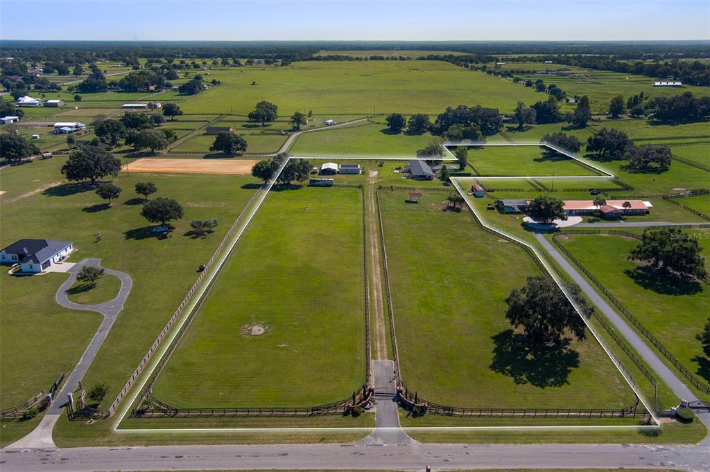 An aerial view shows a fenced rural property with multiple buildings, pastures, and a driveway — 11403 N MAGNOLIA AVENUE, OCALA, FL
