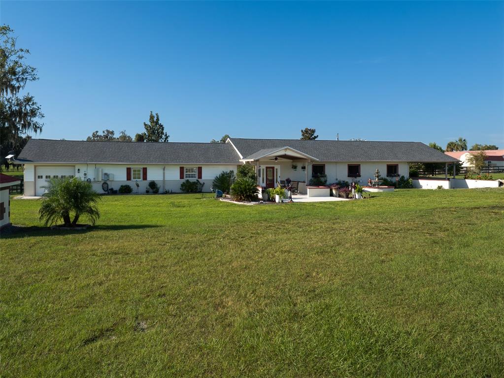 A long, single-story ranch-style house with a gray roof sits on a large grassy lot — 11403 N MAGNOLIA AVENUE, OCALA, FL