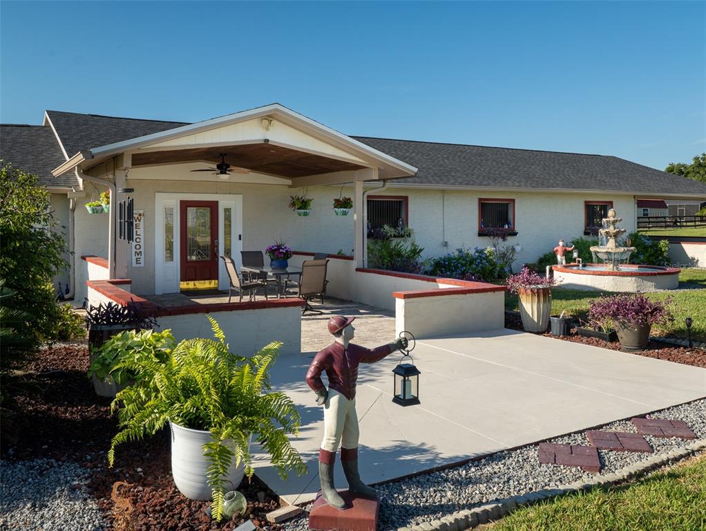 A patio with a covered entrance, a fountain, and a jockey statue in front — 11403 N MAGNOLIA AVENUE, OCALA, FL