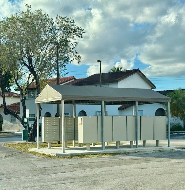 A covered outdoor community mailbox station stands in front of a multi-story residential building — 13539 SW 62nd St # 128, Miami FL 33183, MIAMI, FL