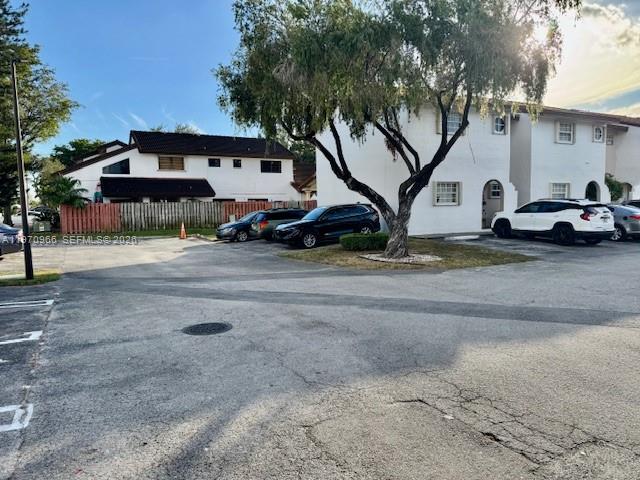 A parking lot sits in front of two-story residential buildings and a large tree — 13539 SW 62nd St # 128, Miami FL 33183, MIAMI, FL