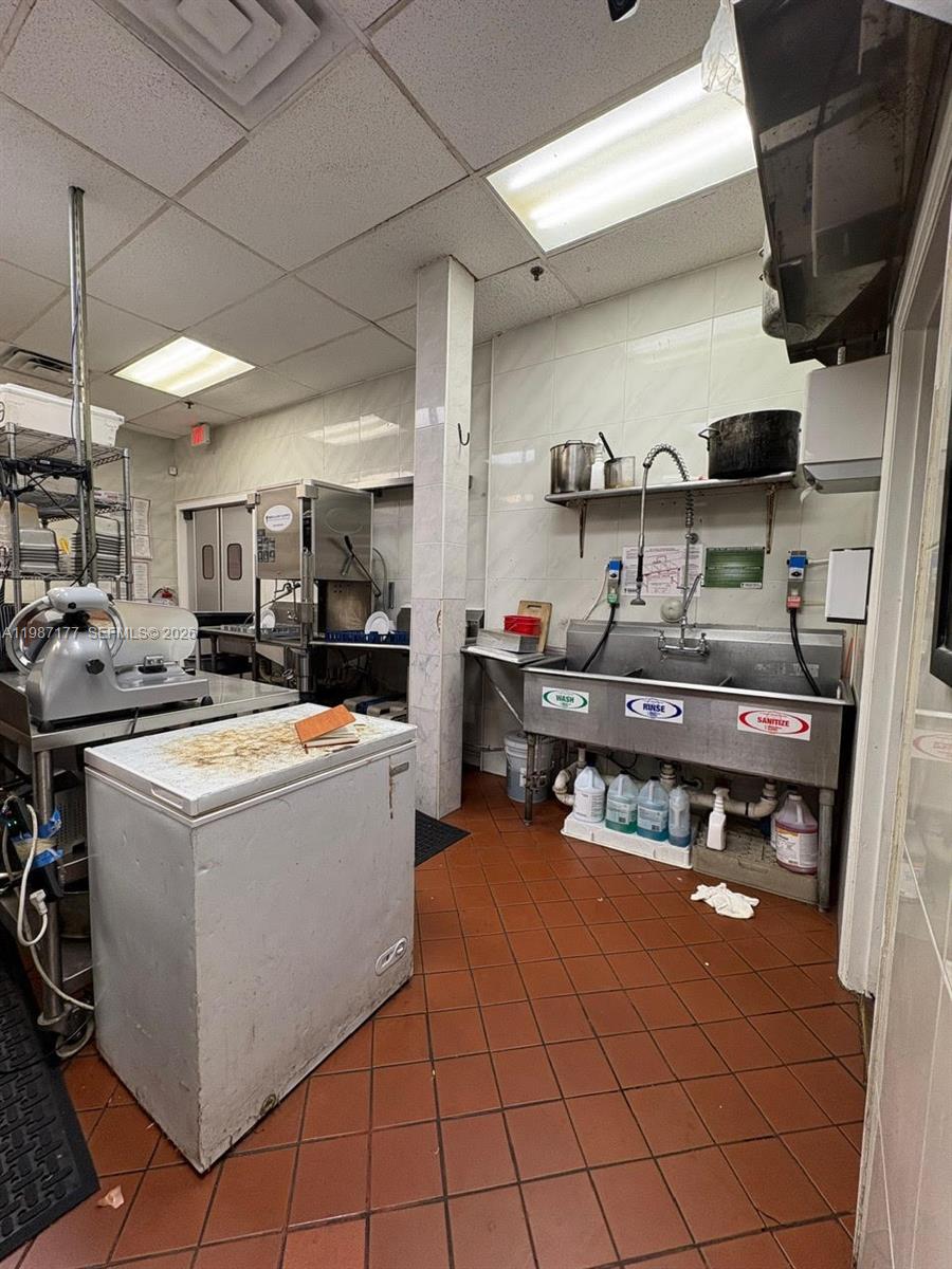 A commercial kitchen features a three-compartment sink, a chest freezer, and stainless steel equipment — Main Road, Weston FL 33327, WESTON, FL