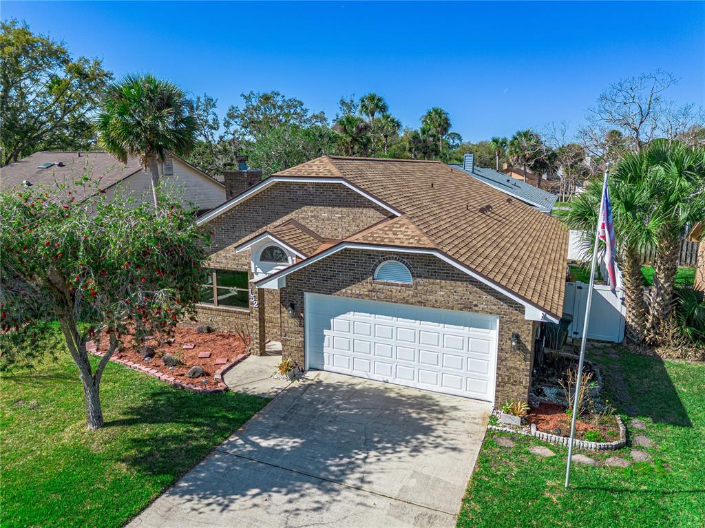 An aerial view of a single-story brick house with a two-car garage and palm trees — 152 LOON COURT, DAYTONA BEACH, FL