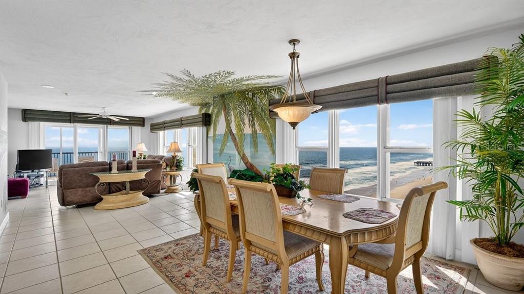 A dining area with a palm tree mural overlooks the ocean through large windows — 3425 S ATLANTIC AVENUE UNIT 1706, DAYTONA BEACH, FL