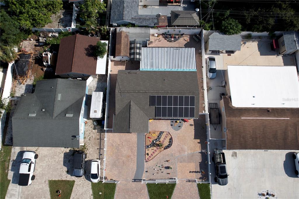 An aerial view shows a house with solar panels, a paved driveway, and a backyard patio — 4527 W ELM STREET, TAMPA, FL