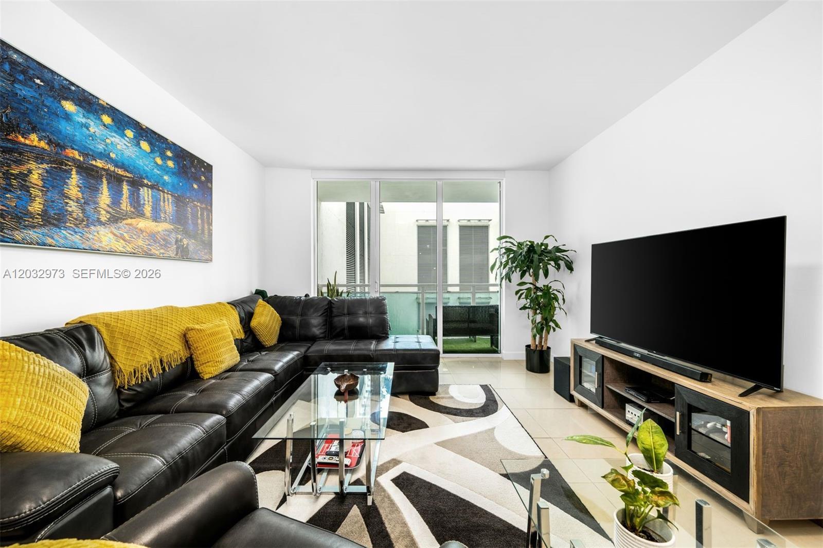 A living room features a black sectional sofa, glass coffee table, and large television — 950 Brickell Bay Dr # 803, Miami FL 33131, MIAMI, FL