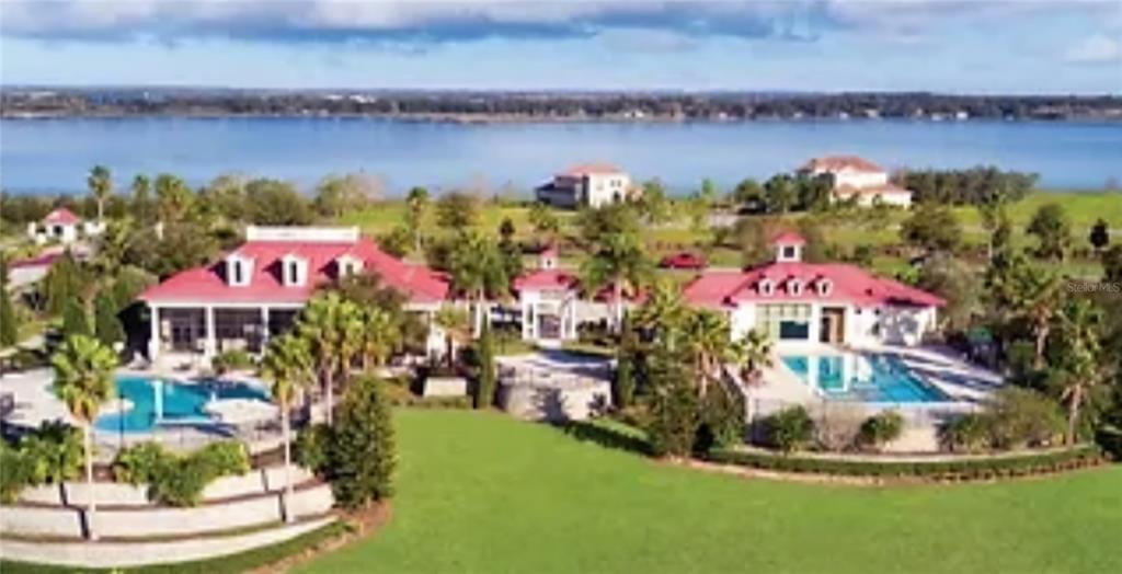 An aerial view of two large houses with red roofs and swimming pools near water — 780 WATERFERN TRAIL DRIVE, AUBURNDALE, FL