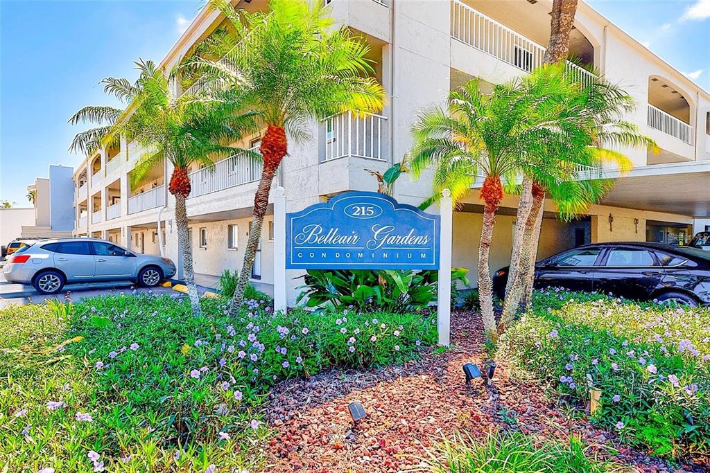A blue sign for Belleair Gardens Condominium stands in front of a multi-story apartment building — 215 VALENCIA BOULEVARD UNIT 213, LARGO, FL